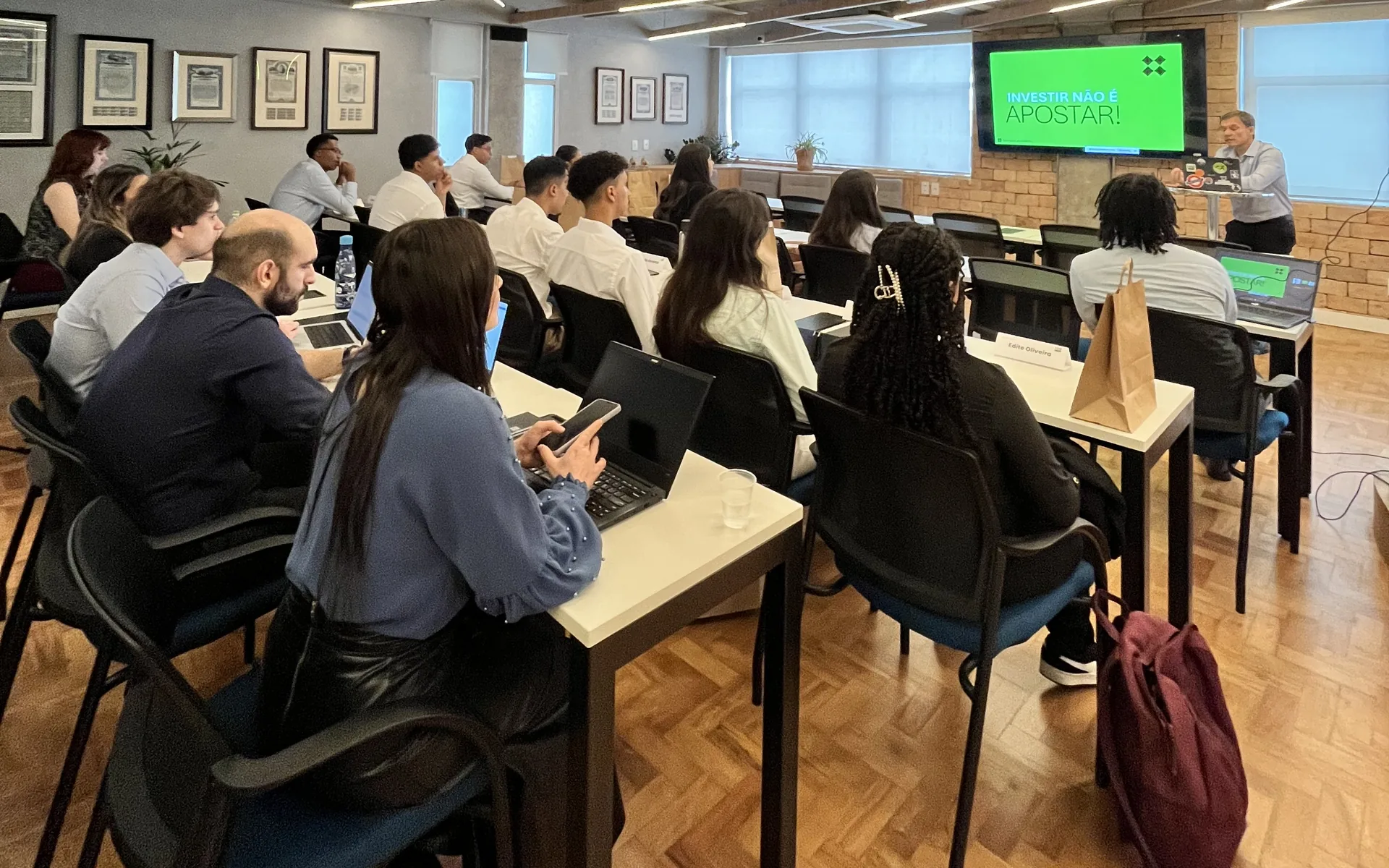 Participantes do You in Banking acompanhando uma aula presencial em sala com notebooks
